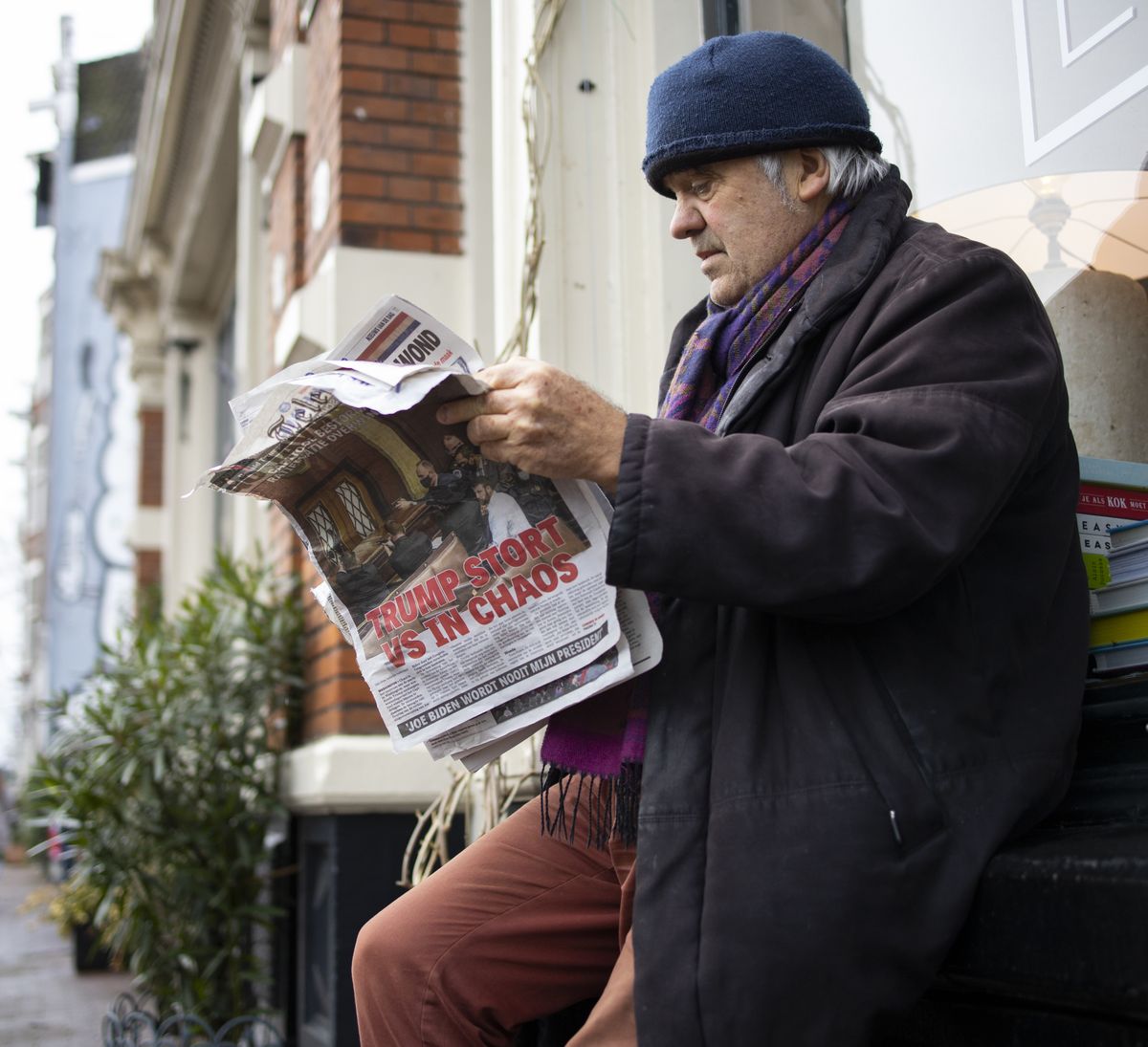 A man reads a newspaper with a headline reading "Trump Plunges U.S. into Chaos" outside a takeaway cafe in the center of Amsterdam, Netherlands, Thursday, Jan. 7, 2021. Congress confirmed Democrat Joe Biden as the presidential election winner early Thursday after a violent mob loyal to President Donald Trump stormed the U.S. Capitol in a stunning attempt to overturn America