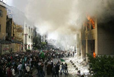 
Demonstrators wave green and black Islamic flags in Beirut, Lebanon, on Sunday in front of the burning building that houses the Danish mission during a protest against publication of caricatures of Islam's prophet in European newspapers. 
 (Associated Press / The Spokesman-Review)