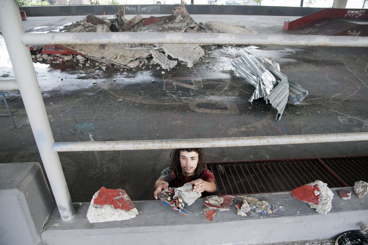 Desmond Hoy, 20, grabs bits of demolished concrete with paint from his and many other graffiti artists