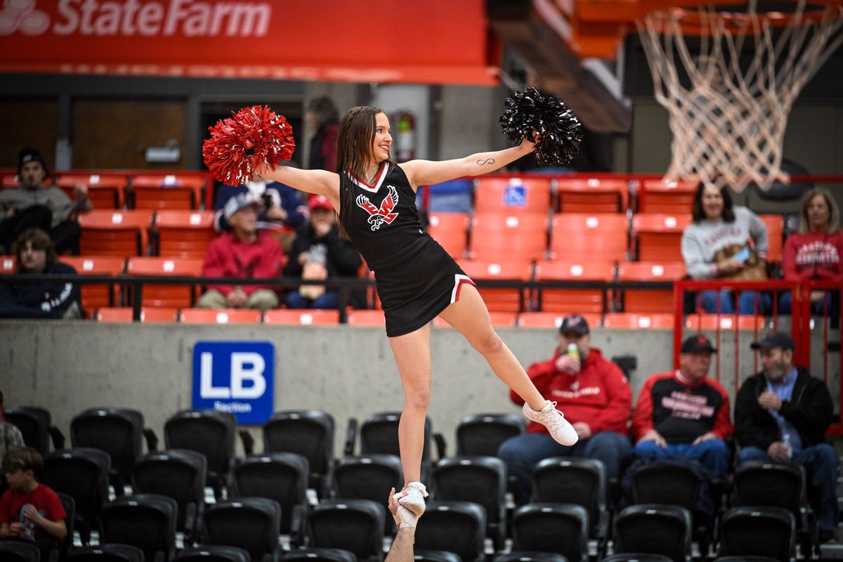 EWU cheerleader Megan Pratley waves to the audience while held aloft by a male cheerleader on Thursday at Reese Court in Cheney. She does not have a right hand, so she performs most routines with a pompom attached to her wrist.  (Jesse Tinsley/THE SPOKESMAN-REVIEW)
