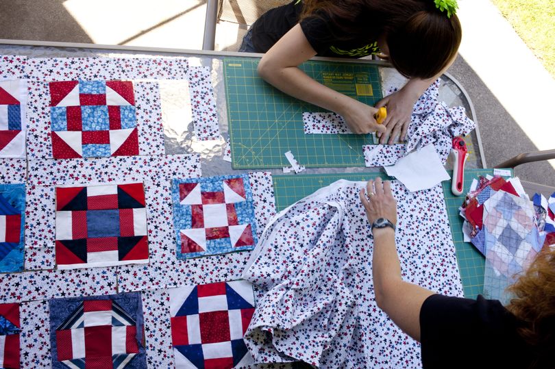Ellin Schafer, 15, above, and her mother, Carolyn, assemble a quilt at their home in Spokane Valley on Tuesday. Carolyn Schafer is organizing a quilting drive for the members of Mason Flemmer’s unit. Flemmer, the orchestra teacher at Central Valley, is being deployed for the third time to Afghanistan. (Tyler Tjomsland)