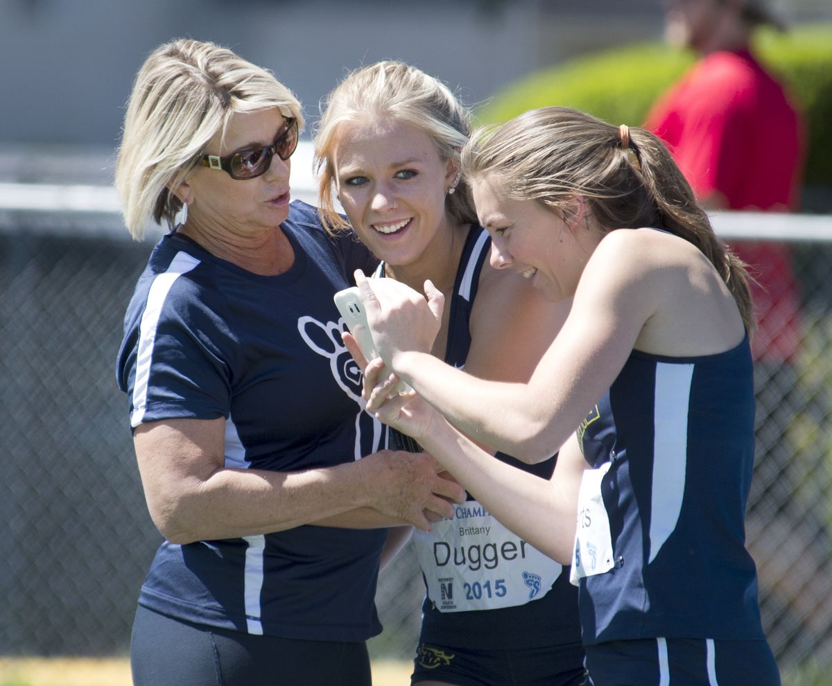Brittany Dugger, center, of CC Spokane, celebrates with coach Linda Lanker, left, and Sidney Roberts after she won the 100 hurdles. (Jesse Tinsley)