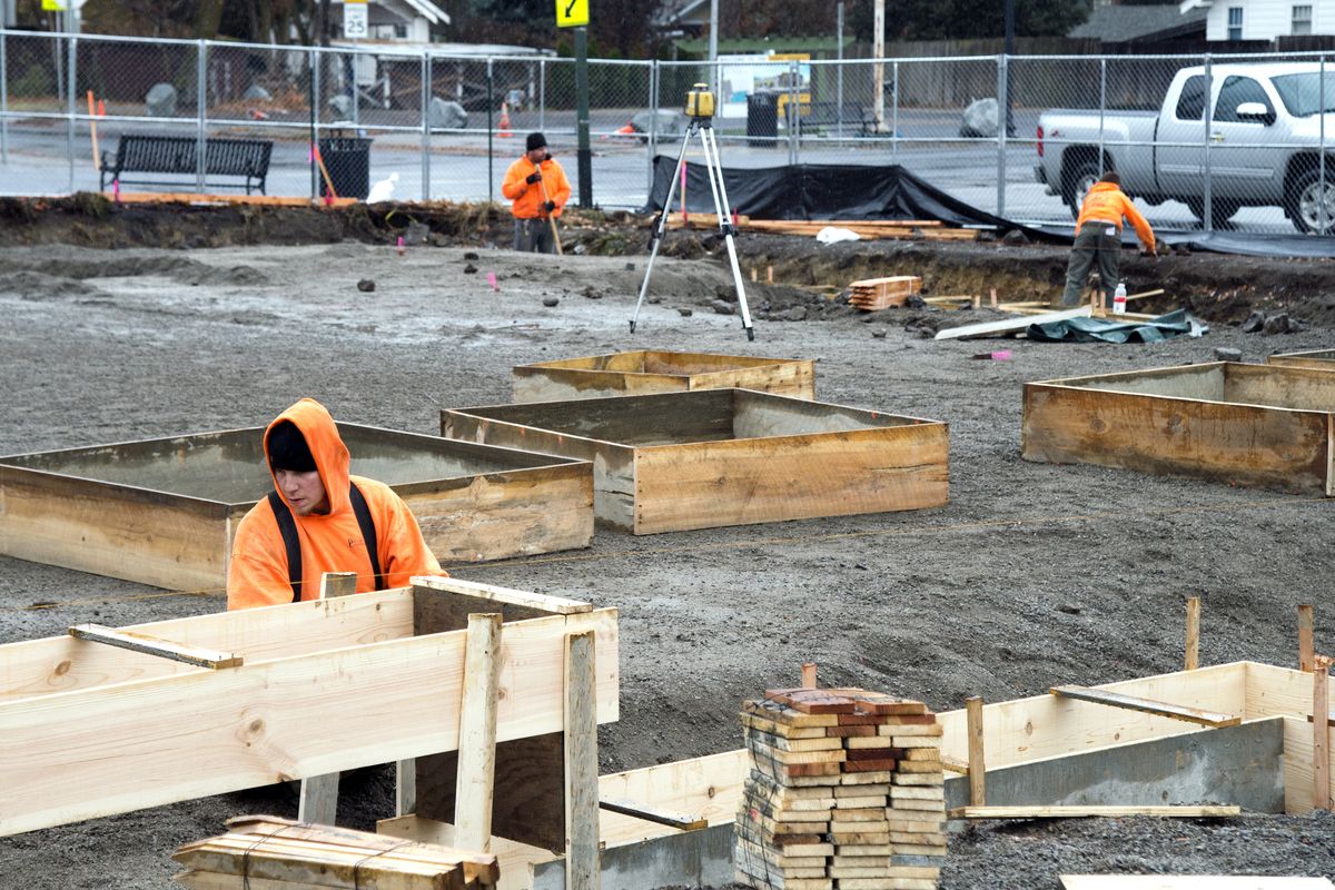Patrick Ruthven, left, Levi Carrillo and Matt Murphy of Dieter Construction work on the foundation of a new two-story commercial building at Ninth Avenue and Perry Street on Tuesday. (Jesse Tinsley)