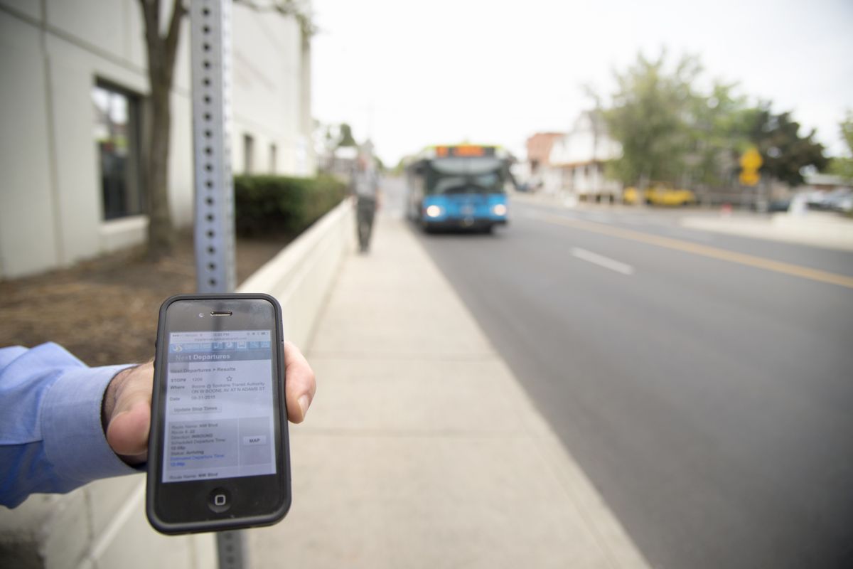 Spokane Transit Authority Director of Operations Steve Blaska holds a smartphone showing the real-time status of the approaching bus outside STA headquarters on Aug. 31. (Jesse Tinsley)
