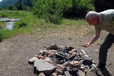 
Ranger Randy Swick inspects an old fire pit filled with broken bottles and beer cans in the Idaho Panhandle National Forests. 
 (Jesse Tinsley / The Spokesman-Review)