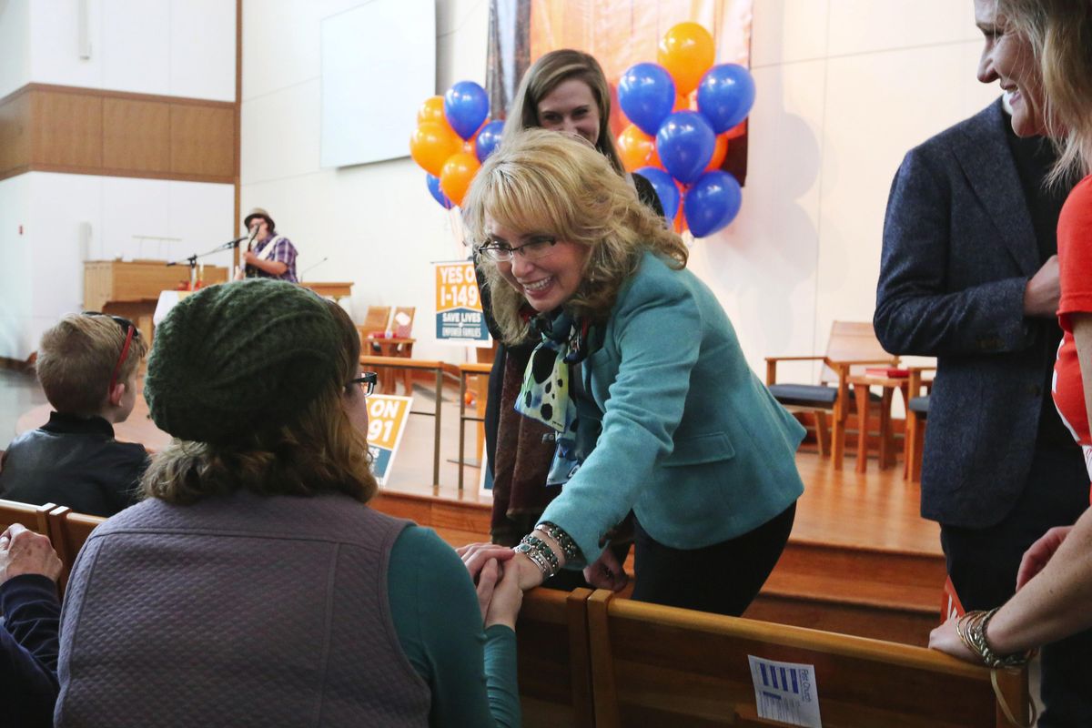 FILE – Former Arizona congresswoman Gabby Giffords greets supporters of I-1491 at the First United Methodist Church for a rally on Saturday, Oct. 22, 2016, in Seattle. The initiative would allow families and law enforcement to petition a court to suspend a person