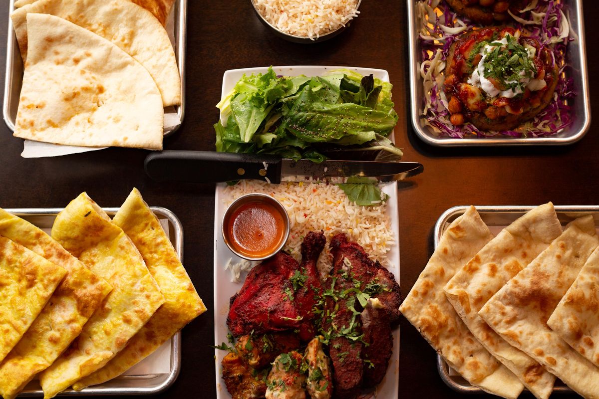A spread of dishes, including the mixed grill plate, naan bread, and aloo tikki is seen at The Mango Tree Indian Kitchen & Tap House on May 23, 2019 in Spokane, Wash. The Spokane location opened May 12 and is located at 401 W. Main Avenue. (Libby Kamrowski / The Spokesman-Review)