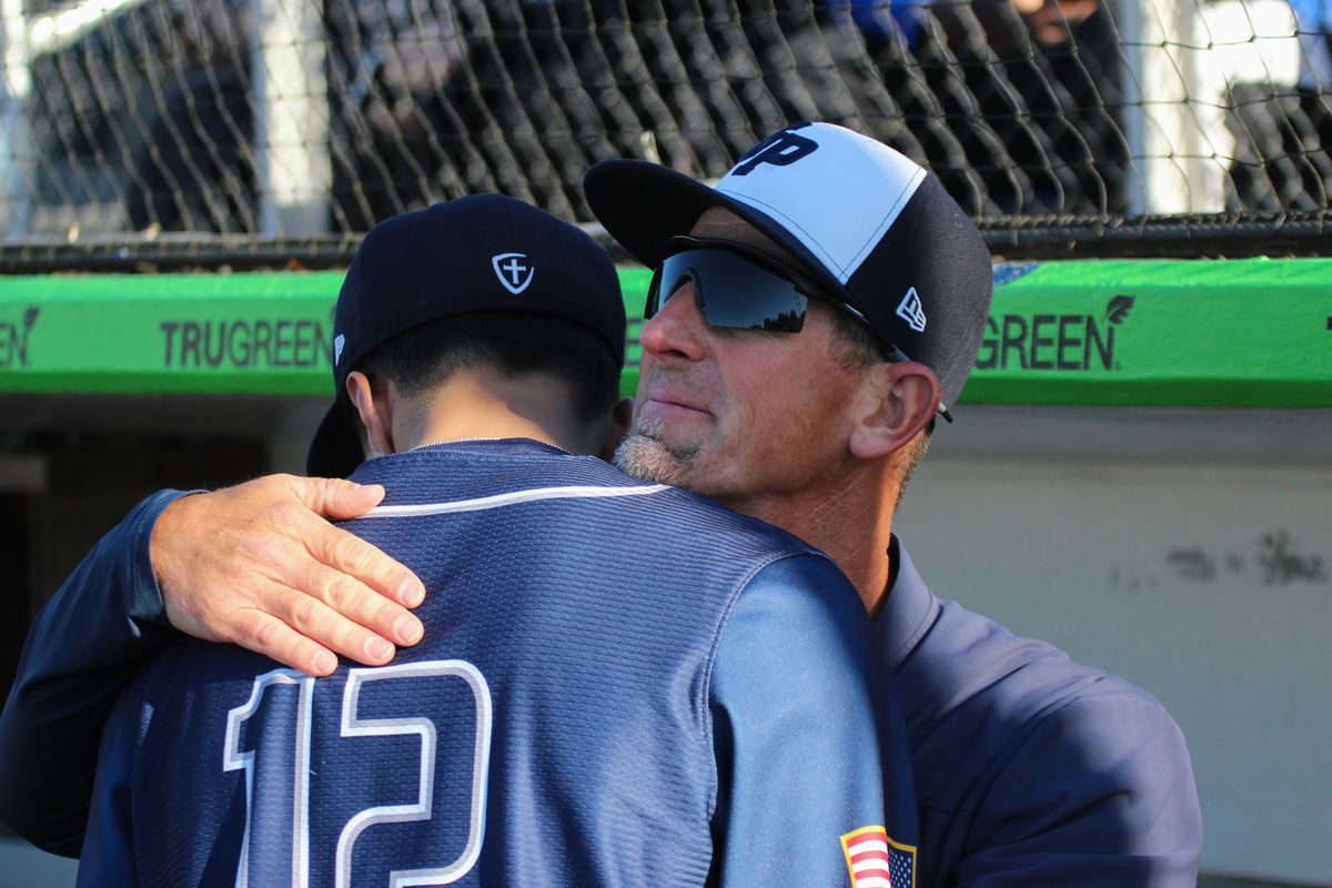 Gonzaga Prep coach Brian Munhall embraces senior pitcher Jacob Wilson after the Bullpups lost to Sumner in the State 4A championship game on Saturday at Funko Field in Everett.  (David Harvey)