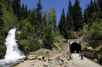 Bicyclists exit the Taft Tunnel and emerge into the surrounding beauty of the national forest last month.  The Taft Tunnel is the longest of several railroad tunnels along the Route of the Hiawatha.  At left is a spring waterfall that will slow to a trickle in the fall. 
 (Photos by Jesse Tinsley / The Spokesman-Review)