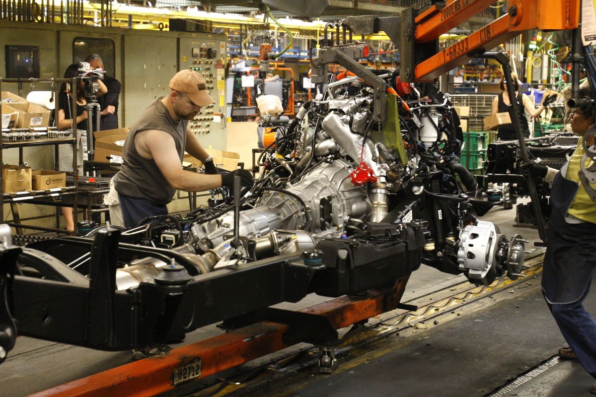 Adam Metzger prepares to mount  an engine to a  chassis on the 2011 GMC Sierra assembly line at the Flint Assembly Plant in Flint, Mich. The manufacturing sector grew in July for the 15th straight month, providing a boost to the slowing economic recovery.  (Associated Press)