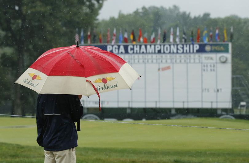 A man stands by the 18th hole after third-round play was suspended Saturday at the PGA Championship at Baltusrol Golf Club in Springfield, New Jersey. (Tony Gutierrez / Associated Press)