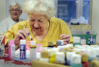
Judy Olsen, left, sets up paints for Janet Wagner as they paint toy trucks made by volunteers at Harbor Crest Retirement Community. In back is Helen Eskeberg. The wooden toys are being prepared for shipment overseas through local charities.
 (Christopher Anderson/ / The Spokesman-Review)