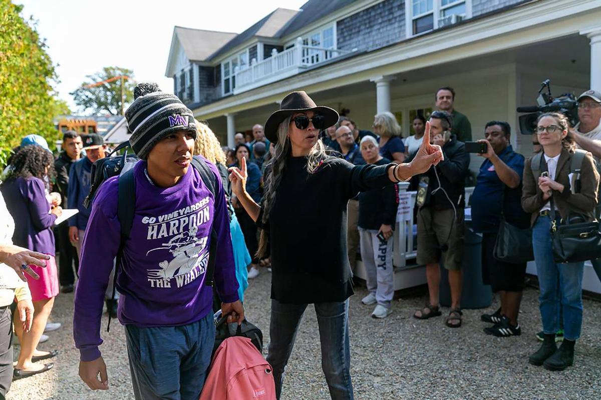 A Venezuelan migrant is led onto a bus at St. Andrews Episcopal Church on Friday, Sept. 16, 2022, in Edgartown, Massachusetts, on the island of Martha