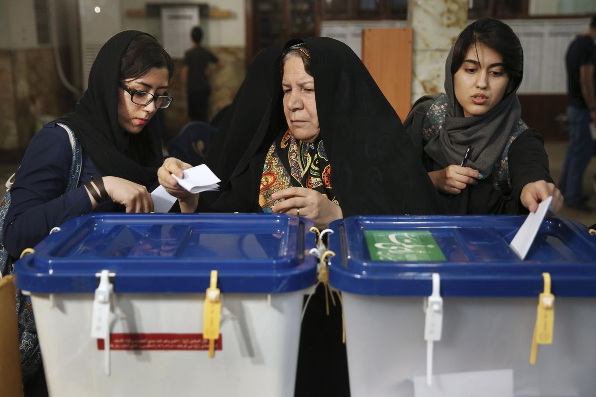 Iranian voters cast their ballots during the parliamentary and Experts Assembly elections in a polling station in Tehran, Iran, . (Vahid Salemi / Associated Press)