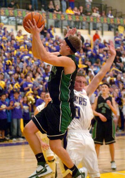 
East Valley High senior Trevor Slocum  flies to the basket past Roger's Andrew Durant during the Gauntlet rivalry game at Rogers High School Friday.
 (Jesse Tinsley / The Spokesman-Review)