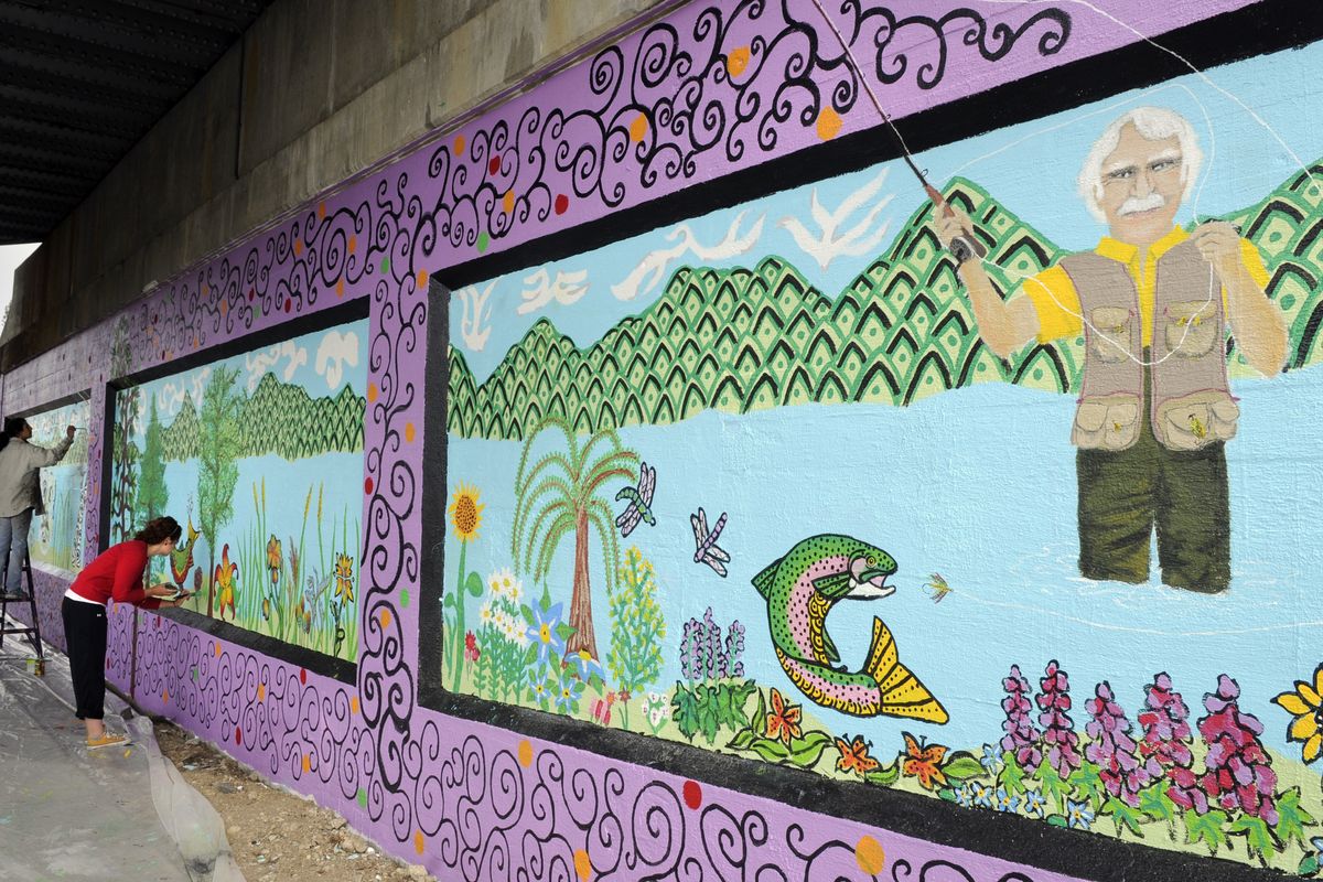Melissa Cole, 43, and Sarah Pierce, 18, add a few final touches of detail to the railway underpass at Fourth Avenue and Sunset Boulevard on July 1. The theme for this mural is “The Wacky World of Harold Balazs.”  (Dan Pelle)