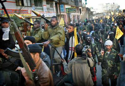 
Palestinian militants of the Al-Aqsa Martyrs Brigades, a militia linked to Fatah movement, hold their rifles during a rally Thursday against the plan to collect weapons from the militant factions in Nuseirat refugee camp in southern Gaza Strip.
 (Associated Press / The Spokesman-Review)