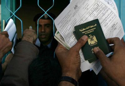 
Palestinians hold  passports to be checked at the Rafah border crossing between the Gaza Strip and Egypt on Saturday. For the first time in nearly four decades, Palestinians didn't have to submit to Israeli security checks to leave the coastal strip. 
 (Associated Press / The Spokesman-Review)