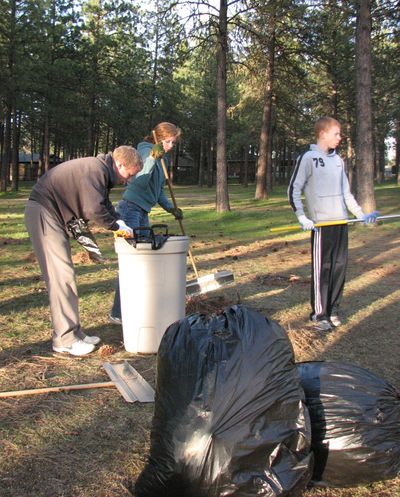 From left, Sam Ferris, Hannah Ferris and Tom Ferris clean up Northwoods Park on Monday. Two dozen people showed up with rakes, bags and brooms. (Pia Hallenberg)