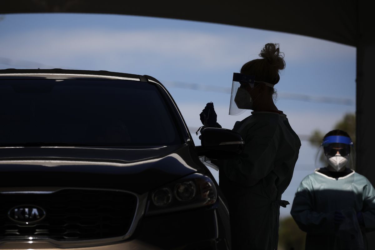 FILE - In this July 10, 2020, file photo healthcare workers test patients in their cars at a drive-thru coronavirus testing site in Las Vegas.  (John Locher)