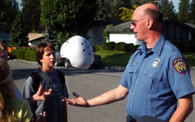 
Spokane Valley Firefighter Casey Parr hands out free bike helmets to kids outside Bowdish Middle School in the Valley on Thursday. Liberty Lake and Spokane Valley bike patrols kick into full gear today. 
 (Liz Kishimoto / The Spokesman-Review)