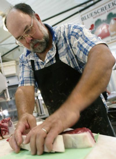
David Smith, owner of Bluescreek Farm in Marysville, Ohio, cuts steaks in his shop Friday in Columbus, Ohio. Smith, who raises homegrown and naturally raised beef, said his business has improved since the nation's first case of mad cow disease was confirmed in December 2003.
 (Associated Press / The Spokesman-Review)