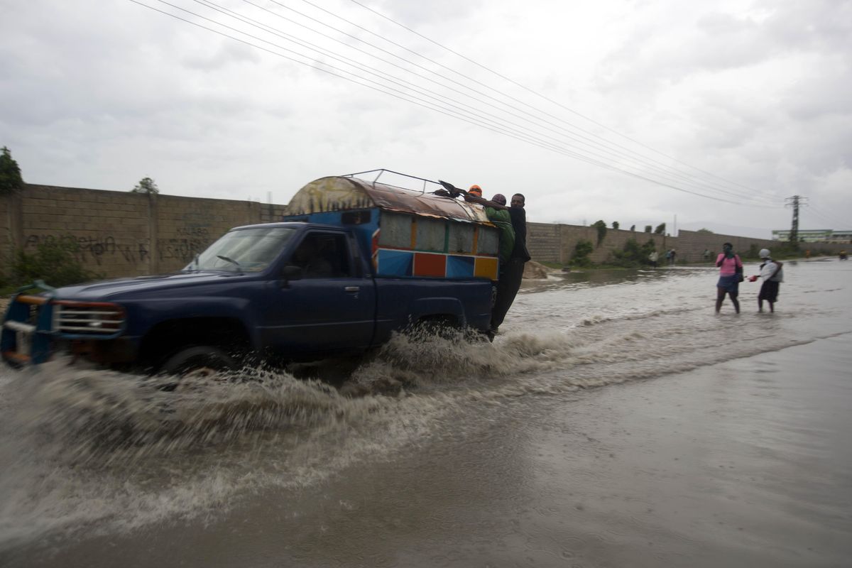 A “tap-tap” truck carrying commuters drives through a street flooded by rain brought by Hurricane Matthew in Port-au-Prince, Haiti, Tuesday Oct. 4, 2016. Hurricane Matthew roared into the southwestern coast of Haiti on Tuesday, threatening a largely rural corner of the impoverished country with devastating storm conditions as it headed north toward Cuba and the eastern coast of Florida. (Dieu Nalio Chery / AP)