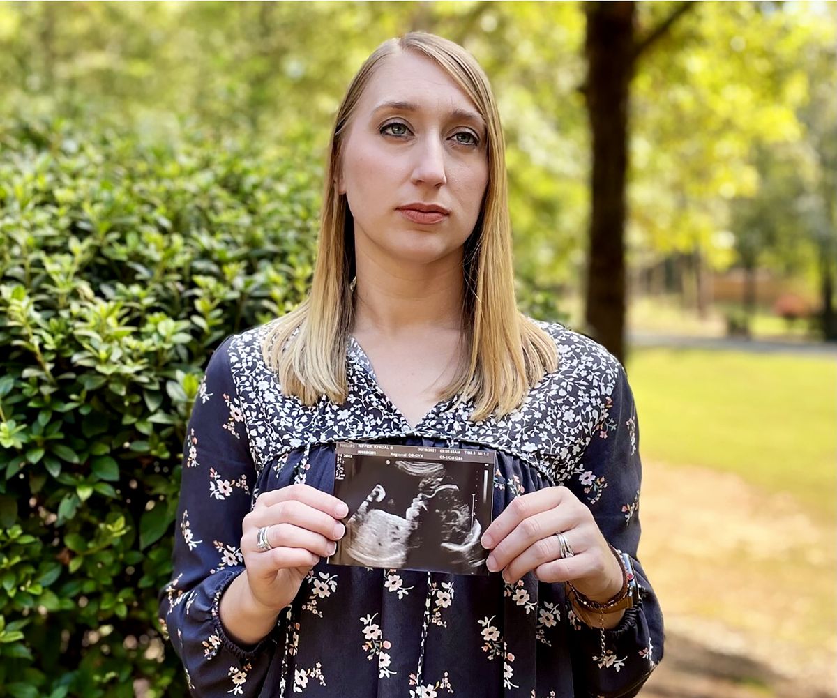 Kyndal Nipper, of Midland, Ga., who suffered a stillbirth after becoming ill with COVID-19 in her third trimester, holds an ultrasound image of the son she lost while standing outside her home on Friday, Oct. 15, 2021. Nipper, who was unvaccinated, is encouraging women to get vaccinated.  (Kim Chandler)