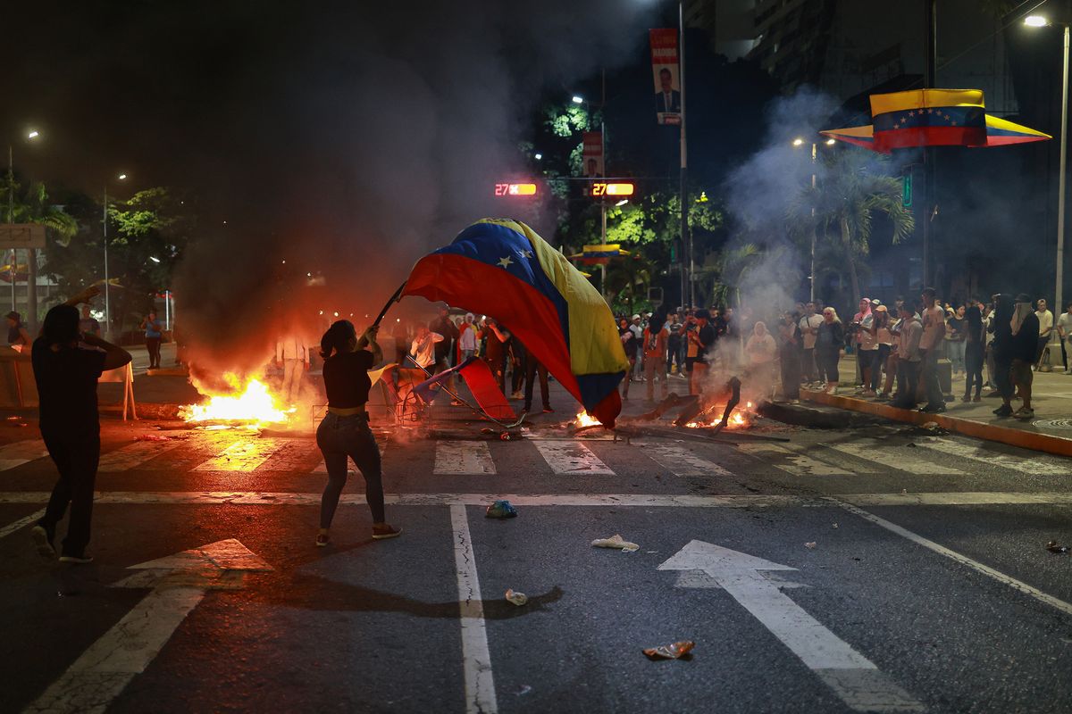 A demonstrator waves a Venezuelan flag during a protest against the official results of the presidential election on July 29 in Caracas, Venezuela.  (Jesus Vargas)