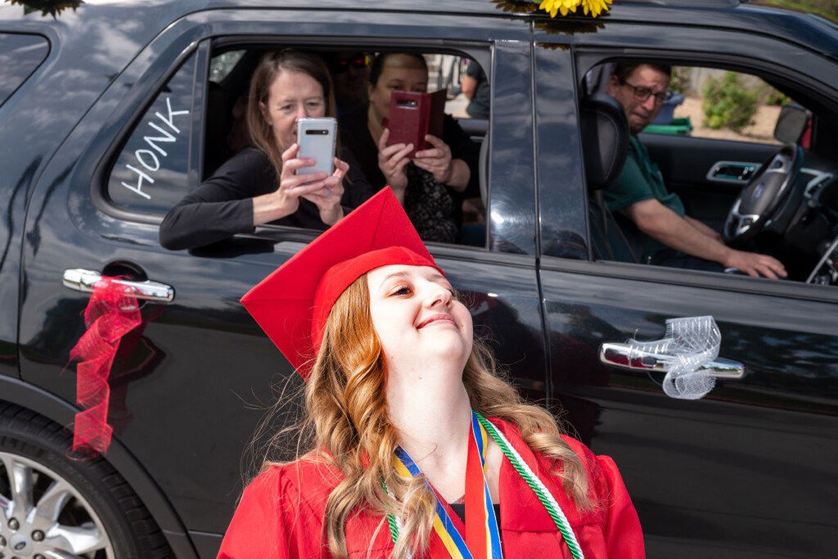 After receiving her diploma during the Ferris High School drive-thru graduation, Madison Anderson leans back to let her mother Kim Anderson take a picture of the top of her decorated mortarboard on Saturday, June 6, 2020.  (Colin Mulvany / The Spokesman-Review)