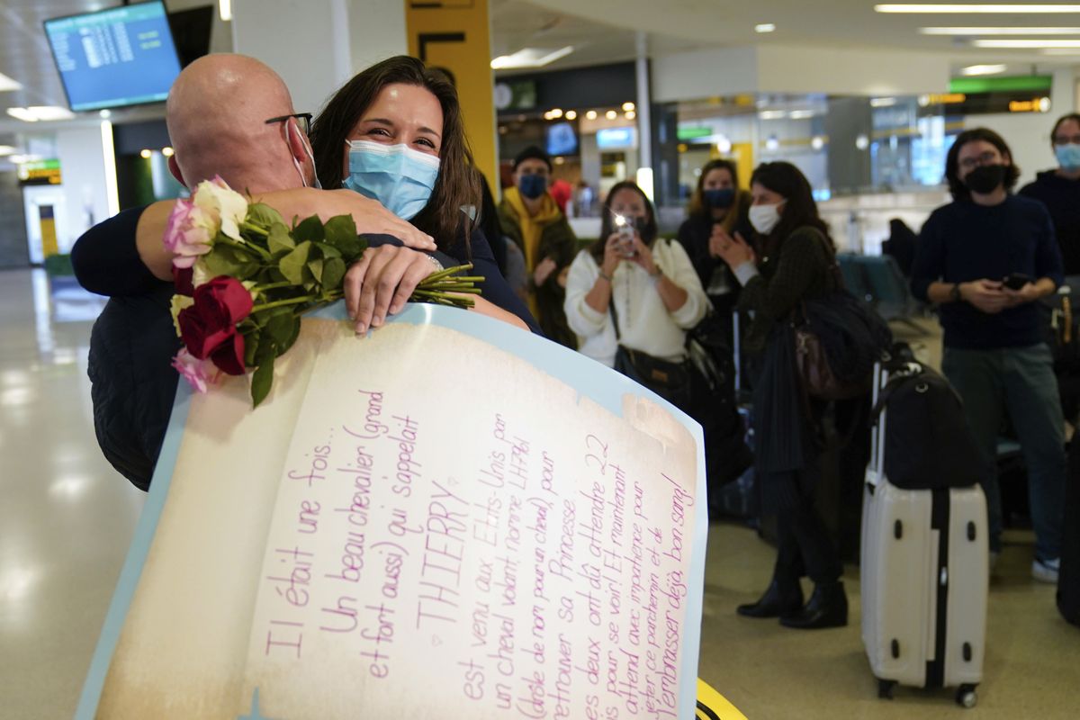 People applaud and take pictures as MaKensi Kastl greets her boyfriend, Thierry Coudassot, after he arrived from France at Newark Liberty International Airport in Newark, N.J., Monday, Nov. 8, 2021. The couple has not seen one another in person for over a year due to pandemic travel restrictions. The U.S. lifted restrictions Monday on travel from a long list of countries including Mexico, Canada and most of Europe, setting the stage for emotional reunions nearly two years in the making and providing a boost for the airline and tourism industries decimated by the pandemic.  (Seth Wenig)