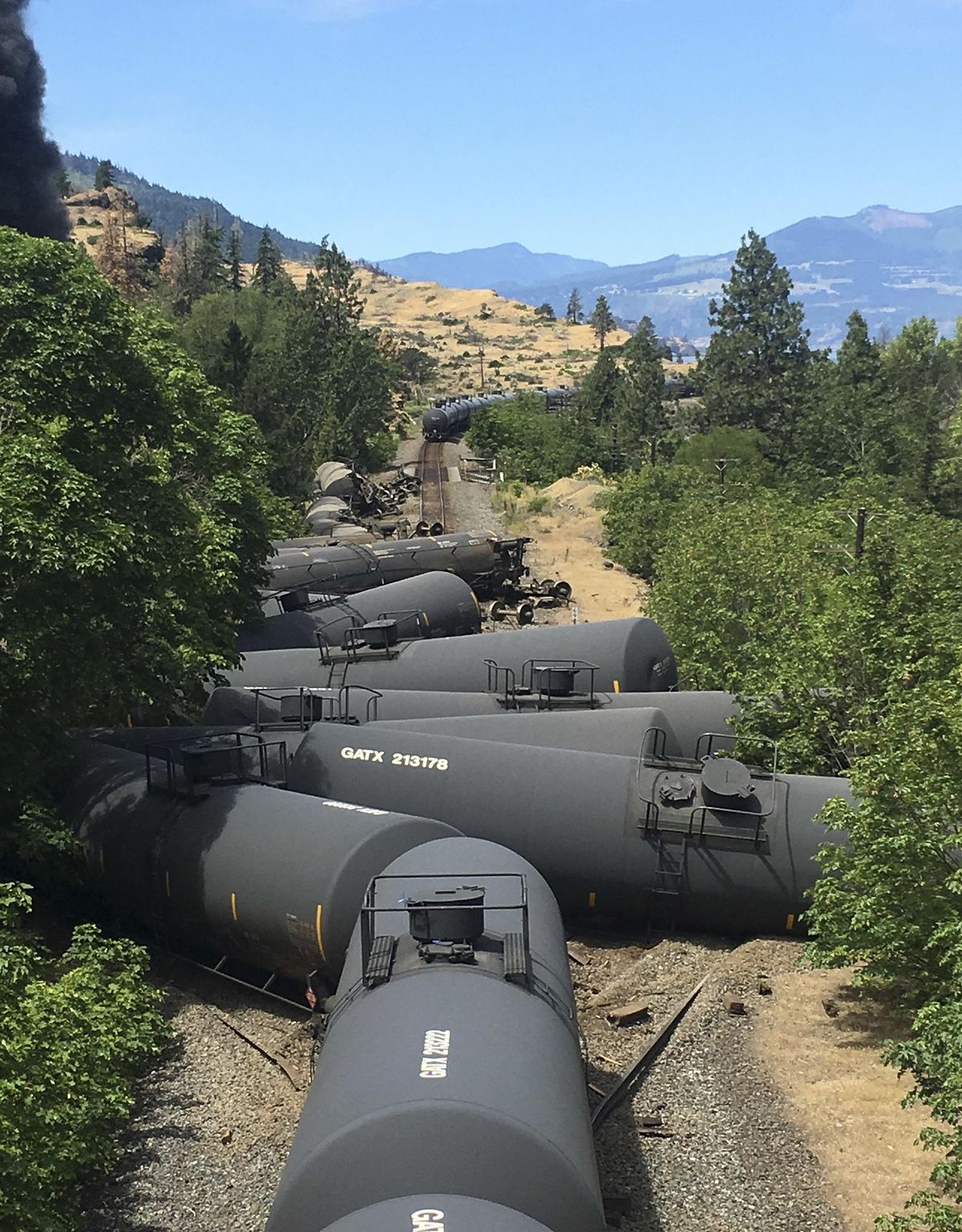 In this photo provided by Silas Bleakley, derailed tank cars, carrying oil, litter the tracks near Mosier, Ore., on Friday, June 3, 2016. (Silas Bleakley / Associated Press)