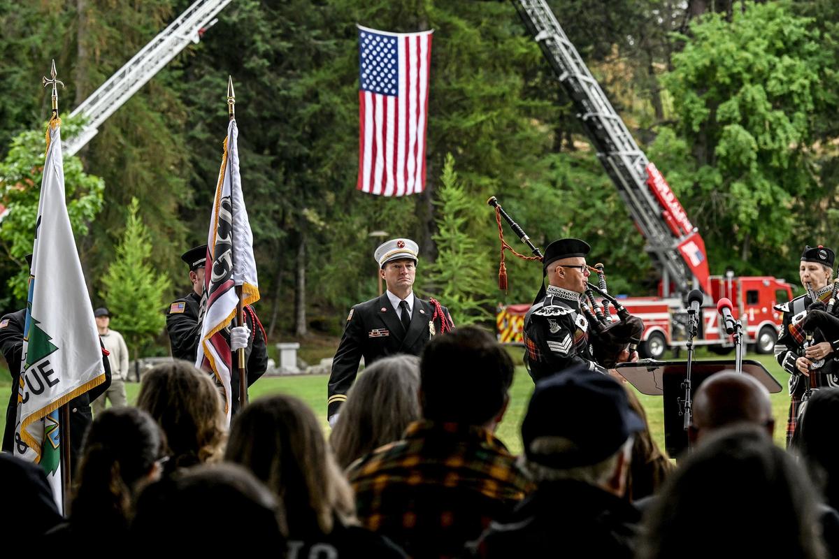 Community members, along with Coeur d’Alene Firefighters Pipes and Drums and North Idaho Joint Honor Guard, gather at Coeur d’Alene’s McEuen Park on Monday to honor the firefighters who were killed in an ambush one year ago on Canfield Mountain.  (Kathy Plonka/The Spokesman-Review)
