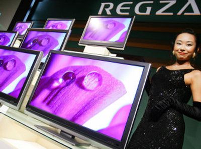 A model shows Toshiba Corp.'s new flat screen televisions with a new brand name