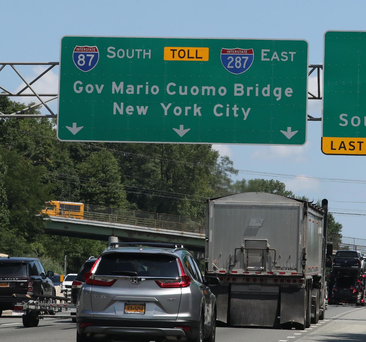 Traffic passes under a sign for the Gov. Mario M. Cuomo Bridge on the New York State Thruway in Nyack, N.Y., on Aug. 1, 2019. The New York State Department of Transportation said Thursday, Aug. 15, 2019, that roughly year-old signs for the suburban bridge named after the former governor are being patched over because his middle initial is missing. (Peter Carr / Associated Press)