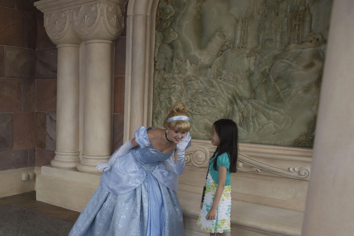 A woman dressed as a Disney character listens to a young Chinese girl during a tour on the eve of the opening of the Disney Resort in Shanghai, China, Wednesday, June 15, 2016. (Ng Han Guan / Associated Press)