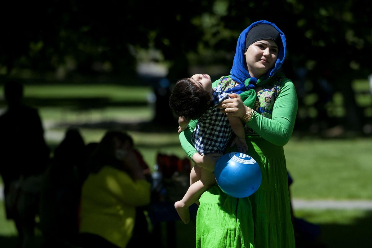 Arezu Kashify carries her son through Manito Park during World refugee Day in Spokane on Saturday, June 29, 2015. She is from Afghanistan. (Kathy Plonka / The Spokesman-Review)