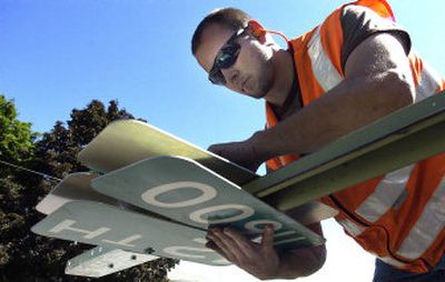 
Jason Green, with the Spokane County sign shop, replaces the street sign at Wilbur and 12th in Spokane Valley on Monday. 
 (Photos by Liz Kishimoto / The Spokesman-Review)