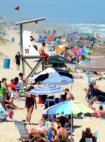 People crowd Wrightsville Beach in Wilmington, N.C., on Sunday as red flags warn swimmers of dangerous conditions and rip currents due to Tropical Storm Beryl. (Associated Press)