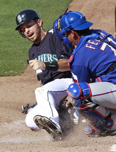  Dustin Ackley slides into home during spring training action in March.  (Ron Ennis / Fort Worth Star-Telegram)