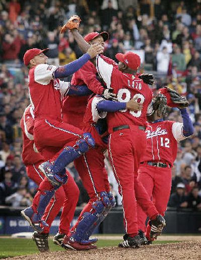 
Teammates surround relief pitcher Pedro Lazo after Cuba's win. 
 (Associated Press / The Spokesman-Review)