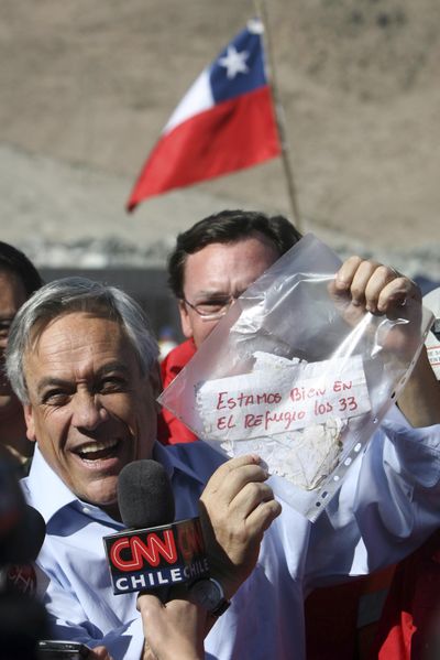 Chile’s President Sebastian Pinera holds up a message, from miners trapped in a collapsed mine,  in Copiapo, Chile, on Sunday.  (Associated Press)