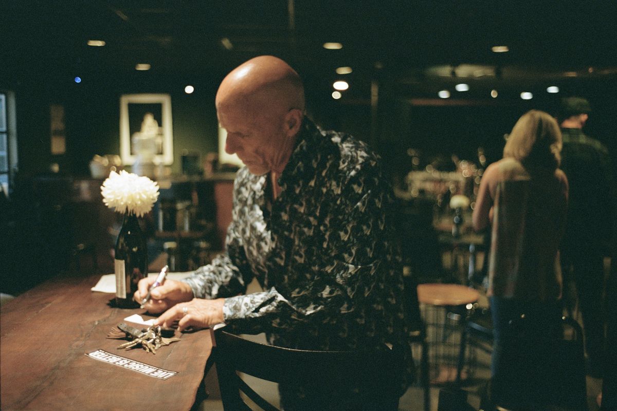 Tim Flannery writes down the name of a friend for the show’s guest list before a performance with his band.  (GABRIELLA ANGOTTI-JONES/New York Times)