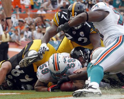 Miami’s Ikaika Alama-Francis (59) lands on a ball fumbled by Steelers QB Ben Roethlisberger. Pittsburgh retained possession and kicked the game-winning field goal on the ensuing play. (Associated Press)