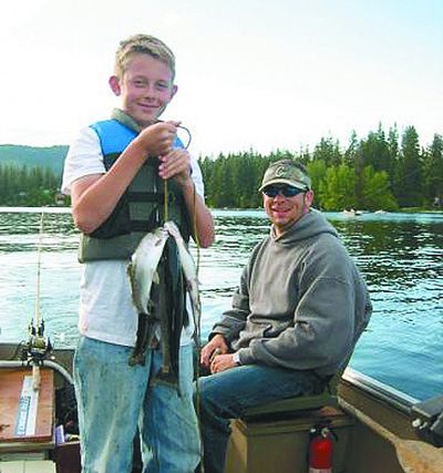 Douglas Wood's stepson, Coty, hoists a stringer of kokanee, fruits of a family fishing trip to Twin Lakes, Idaho, with friend Nate Eldred, right. 