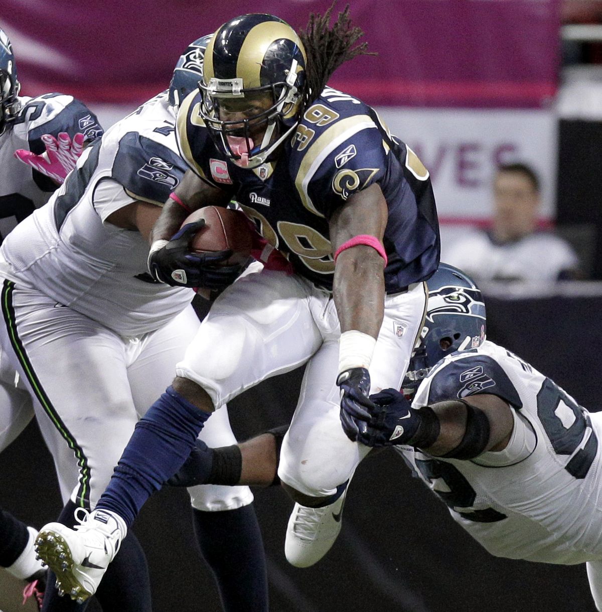 Rams running back Steven Jackson runs through Seattle defenders for a 15-yard gain in the fourth quarter. (Associated Press)