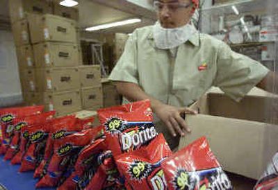 
Frito Lay employee Jesse Gonzales boxes bags of Doritos at the Irving, Texas, plant. Frito-Lay switched from hydrogenated oils containing trans fatty acids to corn oil in cooking some of its most popular salty chips such as Doritos, Tostitos and Cheetos. 
 (Associated Press / The Spokesman-Review)