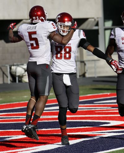 WSU's Isiah Myers, right, is congratulated by Rickey Galvin after Myers scored the winning touchdown against Arizona. (Associated Press)