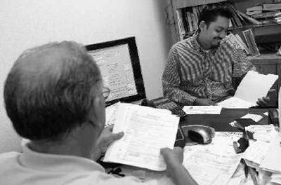 
Carlos Diaz, right, looks over his tax return that was prepared by Esteban Ramirez at Esteban M. Ramirez and Associates in Richmond, Calif.  It's tax time, when millions of illegal immigrants find themselves collaborating with one federal agency - the Internal Revenue Service - while trying to avoid another - Immigration and Customs Enforcement. 
 (Associated Press / The Spokesman-Review)