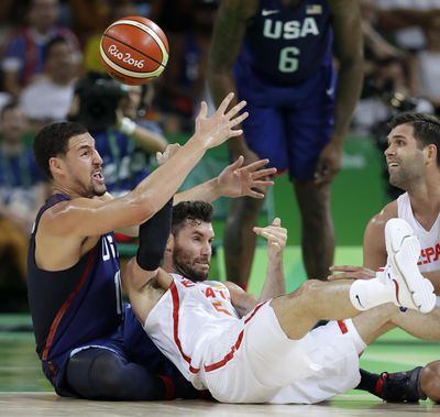 United States' Klay Thompson, left, fights for a loose ball with Spain's Rudy Fernandez during a semifinal round basketball game at the 2016 Summer Olympics in Rio de Janeiro, Brazil, Friday. The U.S. won and advances to the gold-medal game. (Charlie Neibergall / Associated Press)